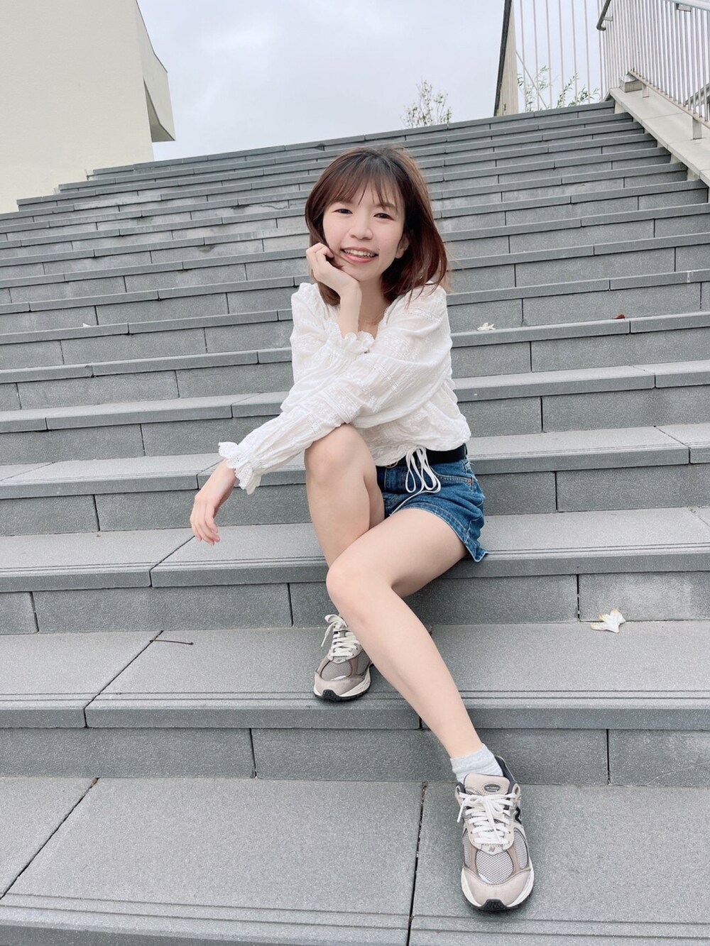 ホワイト系のシャツ/ブラウス、ブルー系のカーゴパンツ、ブラウン系のスニーカーを着用したレディースの夏コーディネートの2枚目の写真
