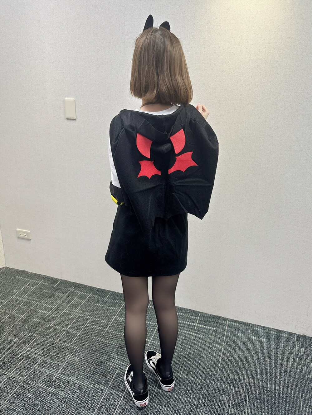 ブラック系のスニーカー、ブラック系のスカート、ホワイト系のTシャツ/カットソーを着用したレディースの秋コーディネートの3枚目の写真