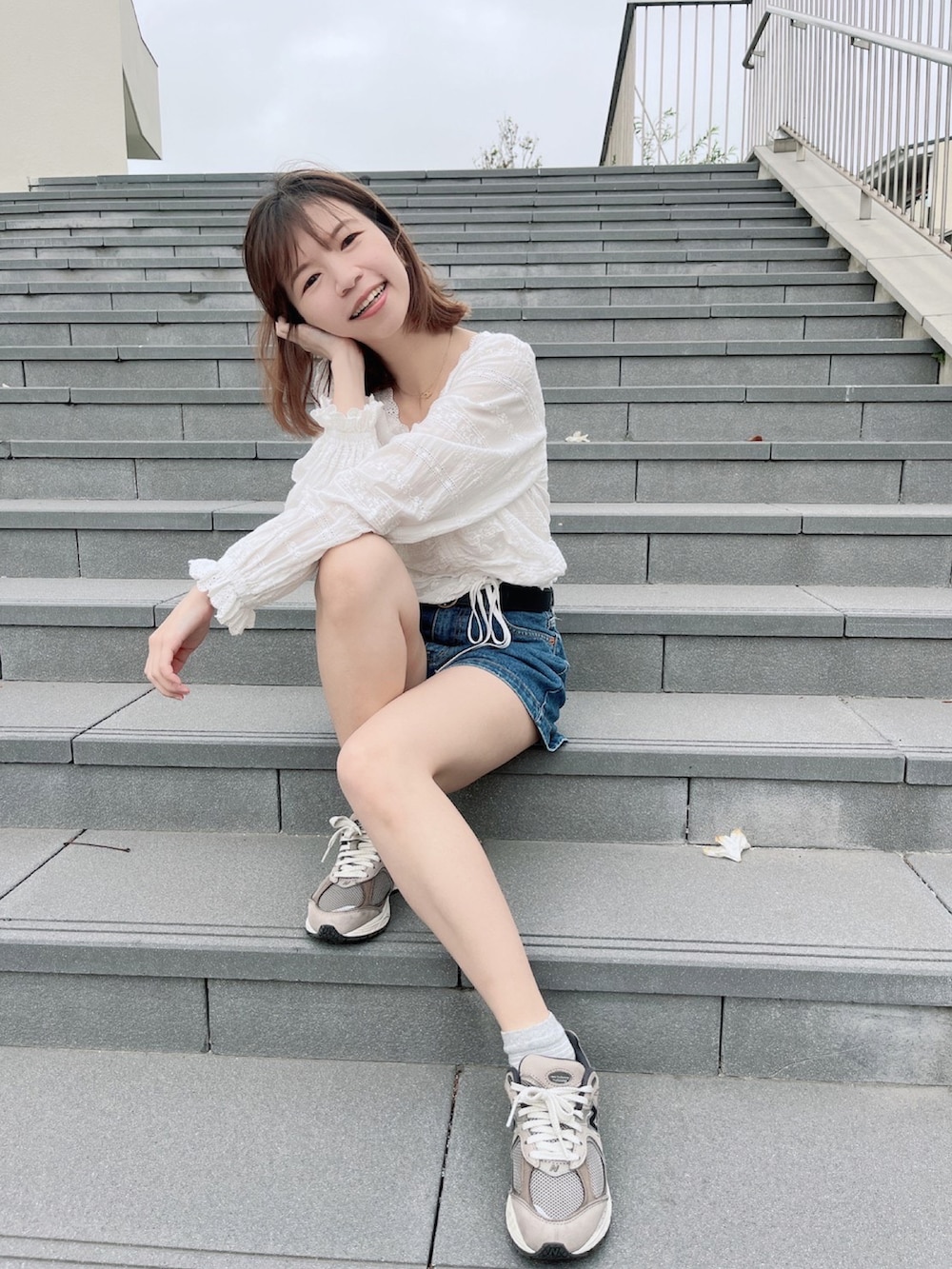 ホワイト系のシャツ/ブラウス、ブルー系のカーゴパンツ、ブラウン系のスニーカーを着用したレディースの夏コーディネートの3枚目の写真