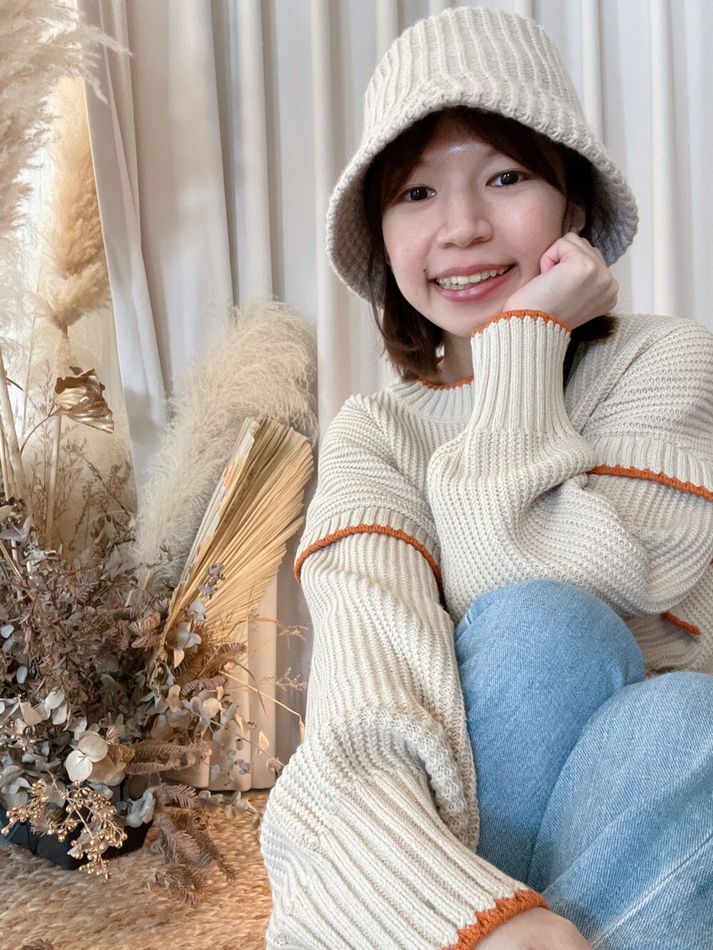 ブルー系のデニムパンツ、ブルー系のショルダーバッグ、ベージュ系のニット/セーターを着用したレディースの春コーディネートの3枚目の写真