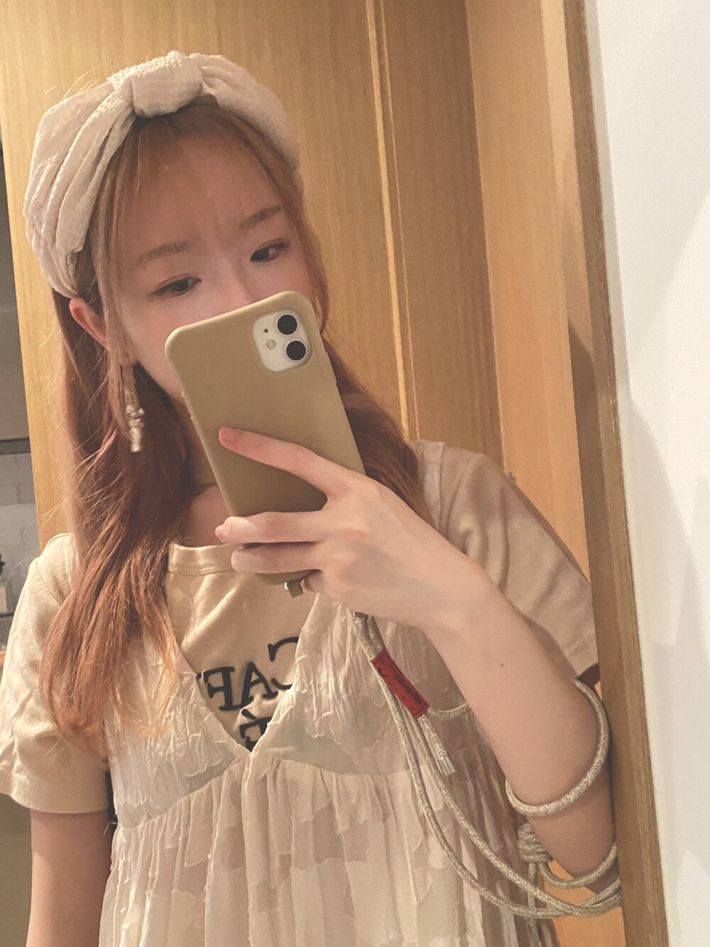 ホワイト系のワンピース、ベージュ系のトップスを着用したレディースの春コーディネートの2枚目の写真