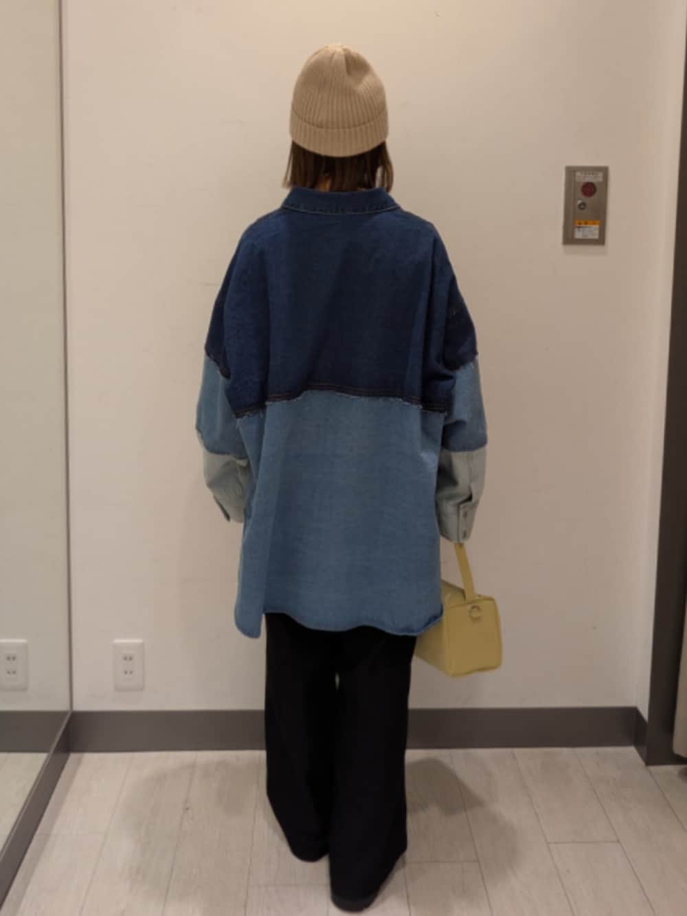 ブルー系のシャツ/ブラウス、イエロー系のトートバッグ、ベージュ系のニットキャップ/ビーニーを着用したレディースの冬コーディネートの4枚目の写真