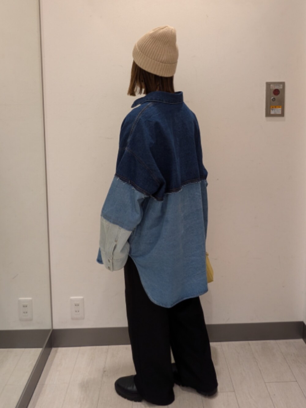 ブルー系のシャツ/ブラウス、イエロー系のトートバッグ、ベージュ系のニットキャップ/ビーニーを着用したレディースの冬コーディネートの3枚目の写真