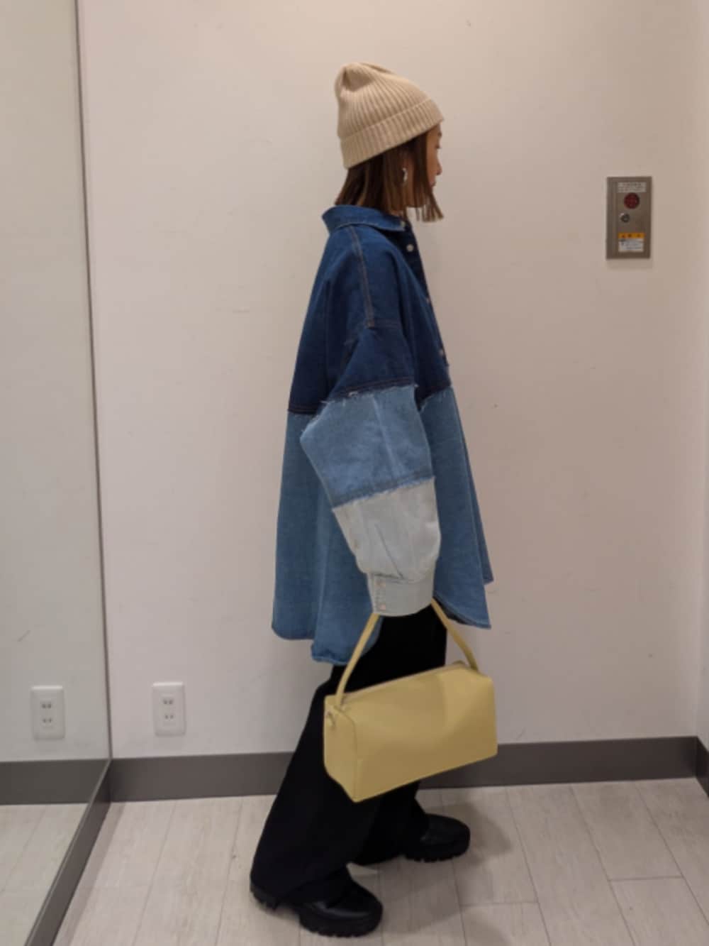 ブルー系のシャツ/ブラウス、イエロー系のトートバッグ、ベージュ系のニットキャップ/ビーニーを着用したレディースの冬コーディネートの2枚目の写真