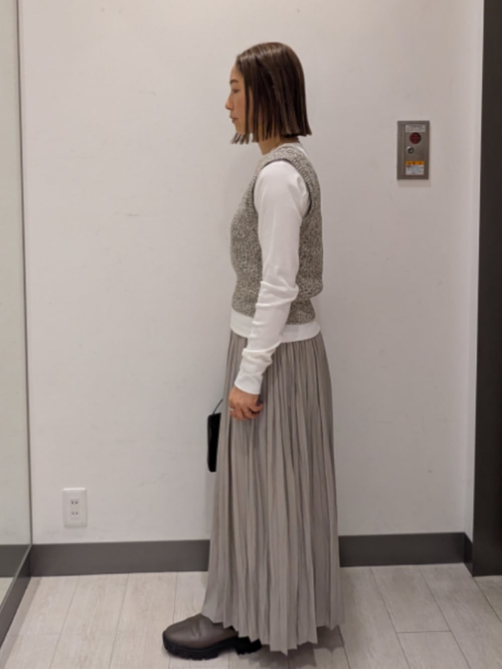 ベージュ系のベスト、ホワイト系のTシャツ/カットソー、ブラック系のトートバッグを着用したレディースの春コーディネートの2枚目の写真