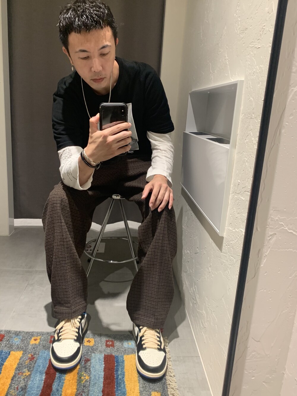 ブラック系のTシャツ/カットソー、ブラック系のトップス、ブラウン系のスラックスを着用したメンズの秋コーディネートの2枚目の写真