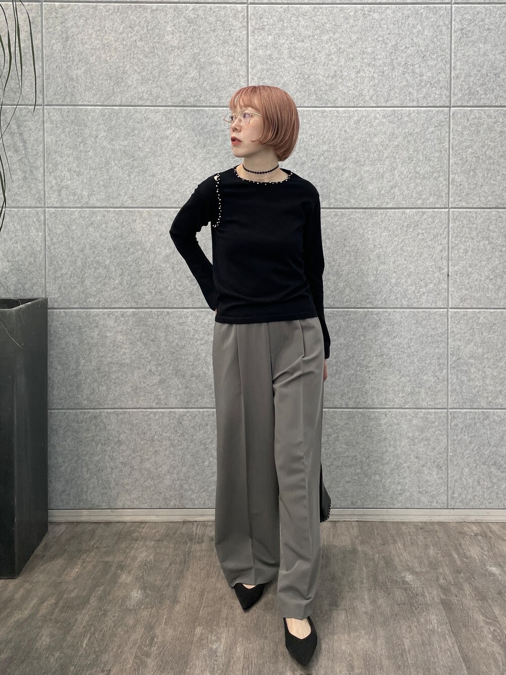 グレー系のその他パンツ、シルバー系のハンドバッグ、ブラック系のニット/セーターを着用したレディースの夏コーディネートの6枚目の写真