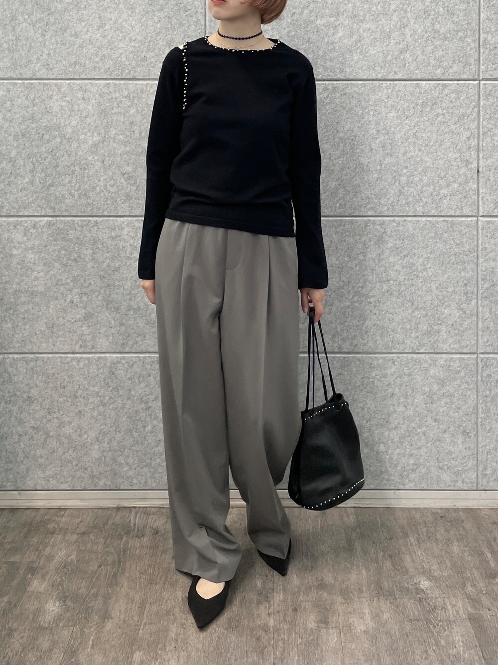 グレー系のその他パンツ、シルバー系のハンドバッグ、ブラック系のニット/セーターを着用したレディースの夏コーディネートの7枚目の写真