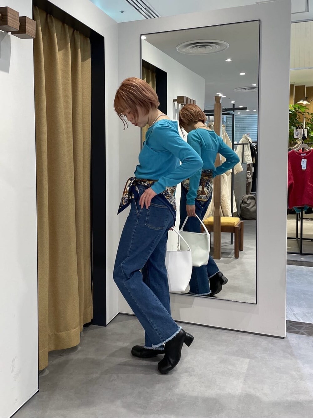 パープル系のTシャツ/カットソー、ブルー系のデニムパンツ、ブルー系のニット/セーターを着用したレディースの冬コーディネートの4枚目の写真