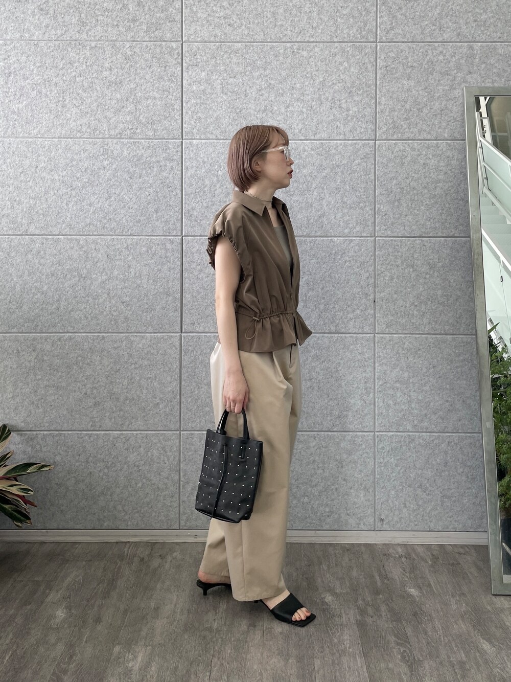 ベージュ系のその他パンツ、ブラック系のトートバッグ、ブラウン系のブルゾンを着用したレディースの春コーディネートの6枚目の写真