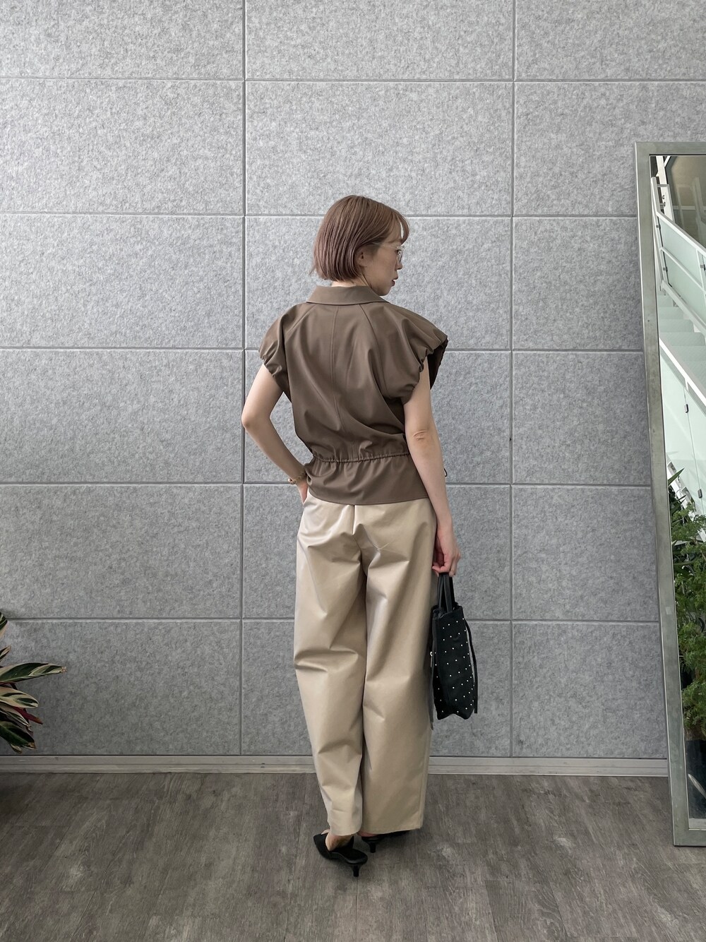 ベージュ系のその他パンツ、ブラック系のトートバッグ、ブラウン系のブルゾンを着用したレディースの春コーディネートの5枚目の写真