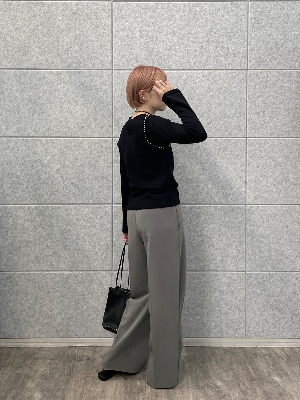 グレー系のその他パンツ、シルバー系のハンドバッグ、ブラック系のニット/セーターを着用したレディースの夏コーディネートの4枚目の写真