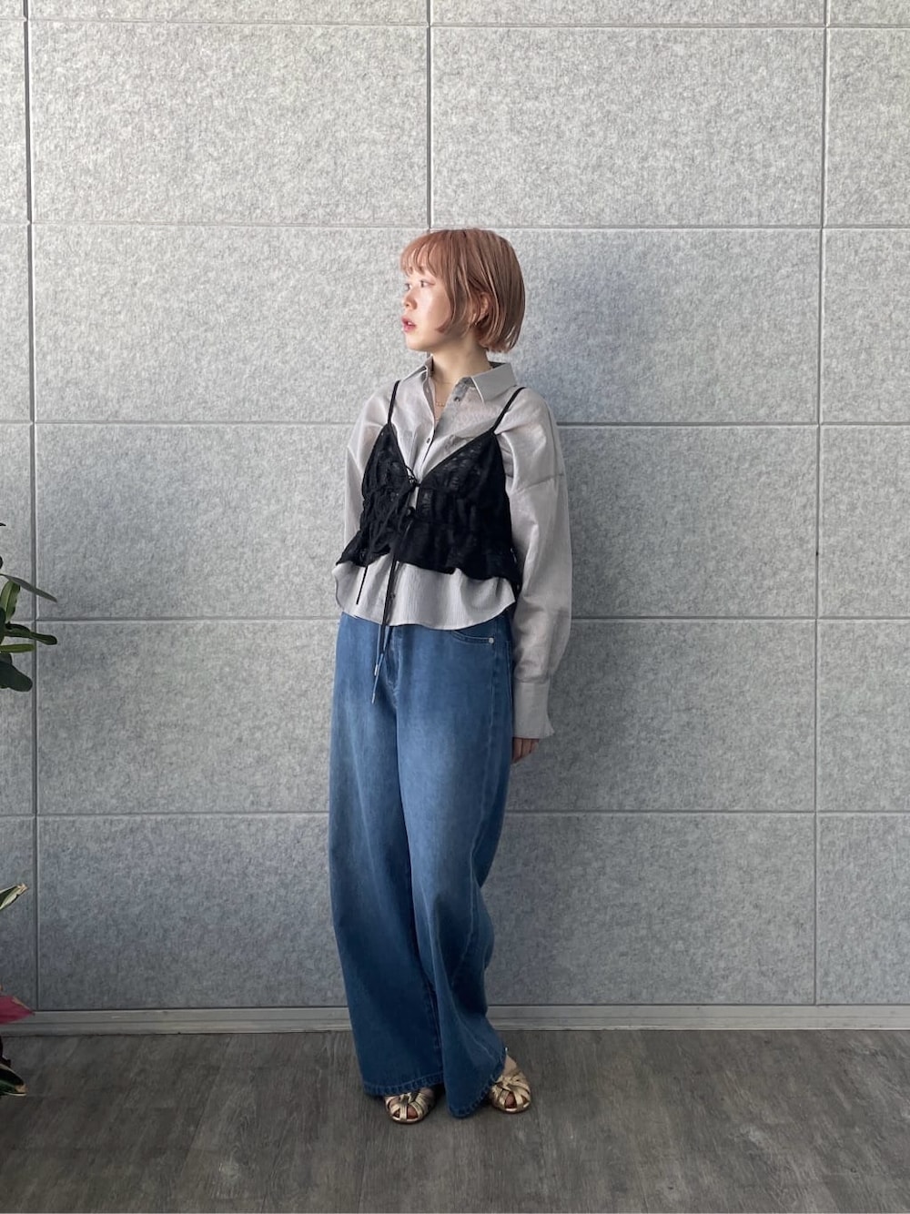 ブルー系のデニムパンツ、グレー系のシャツ/ブラウス、ブラック系のタンクトップを着用したレディースの春コーディネートの2枚目の写真