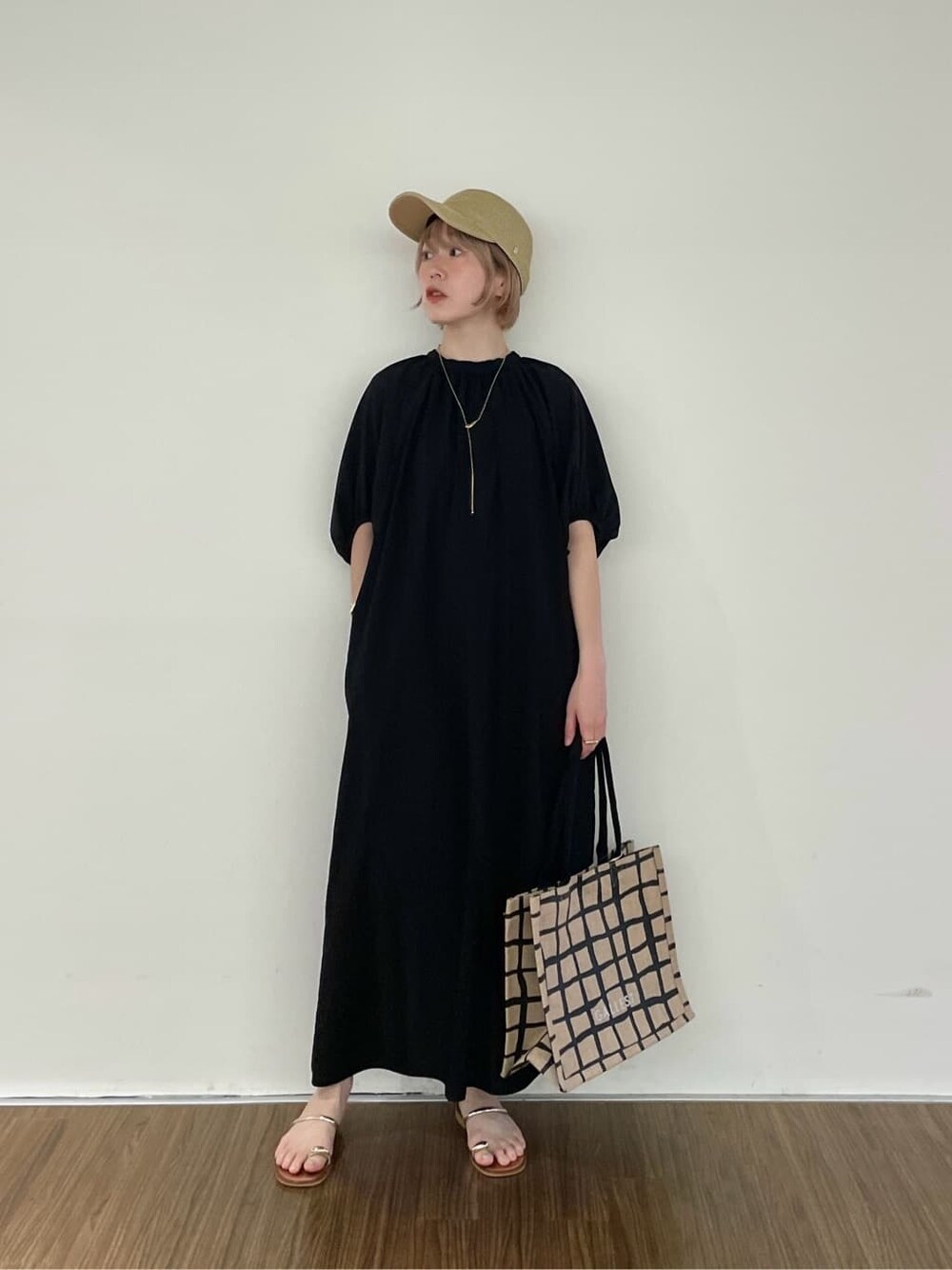 ブラック系のワンピース、ベージュ系のトートバッグ、ゴールド系のリングを着用したレディースの夏コーディネートの9枚目の写真