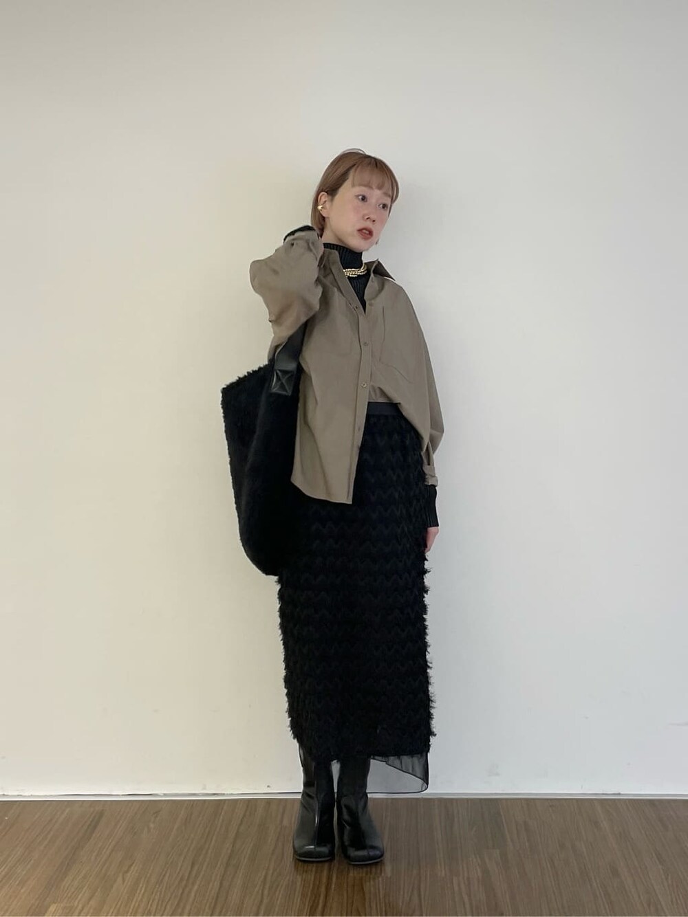 ベージュ系のシャツ/ブラウス、ブラック系のニット/セーター、ブラック系のスカートを着用したレディースの冬コーディネートの7枚目の写真
