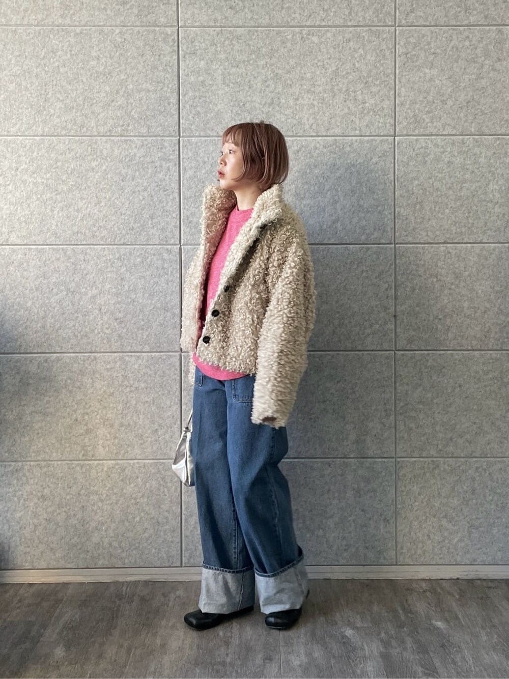 ピンク系のニット/セーター、ブルー系のデニムパンツを着用したレディースの冬コーディネートの4枚目の写真