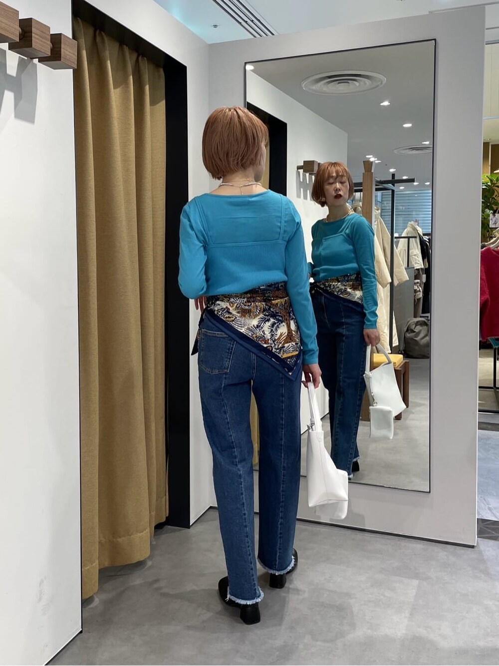 パープル系のTシャツ/カットソー、ブルー系のデニムパンツ、ブルー系のニット/セーターを着用したレディースの冬コーディネートの5枚目の写真