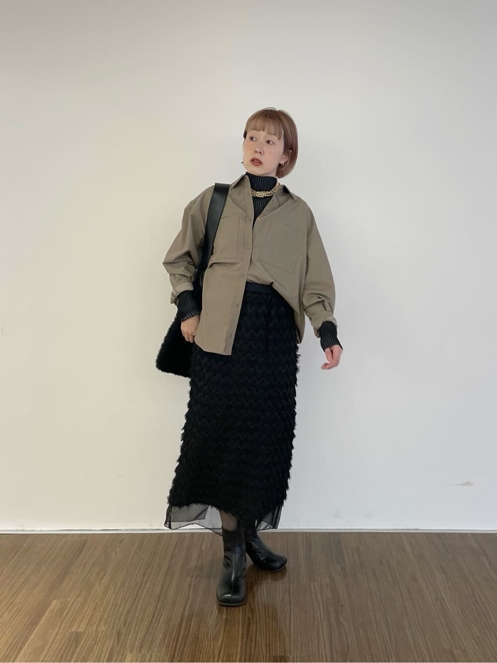 ベージュ系のシャツ/ブラウス、ブラック系のニット/セーター、ブラック系のスカートを着用したレディースの冬コーディネートの8枚目の写真