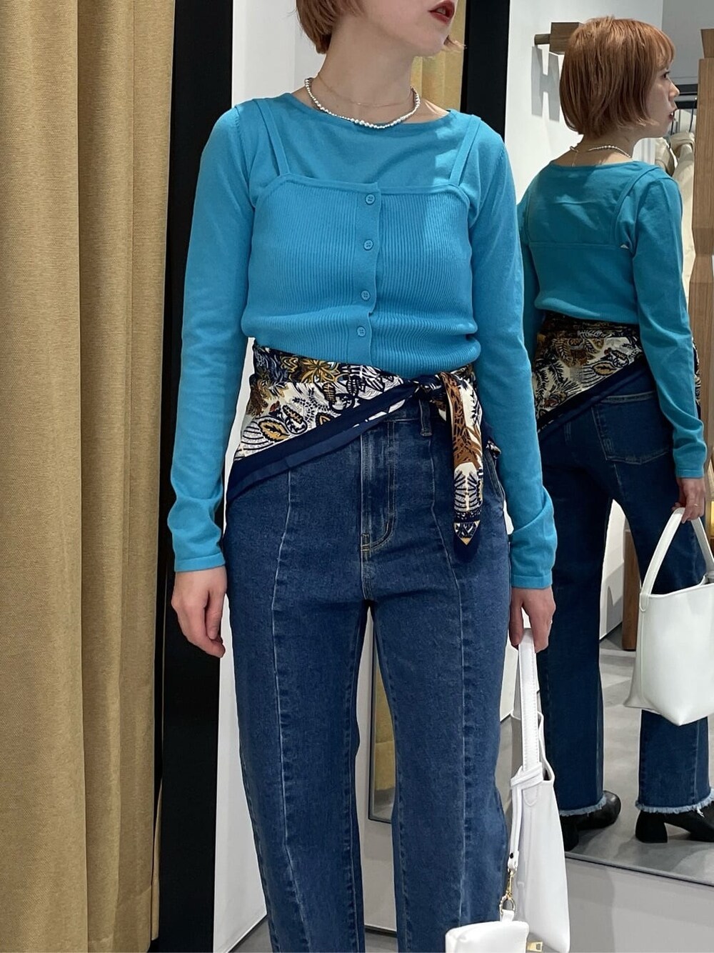 パープル系のTシャツ/カットソー、ブルー系のデニムパンツ、ブルー系のニット/セーターを着用したレディースの冬コーディネートの6枚目の写真