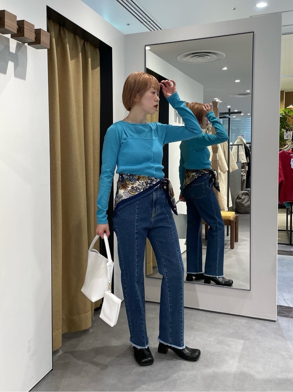 パープル系のTシャツ/カットソー、ブルー系のデニムパンツ、ブルー系のニット/セーターを着用したレディースの冬コーディネートの2枚目の写真