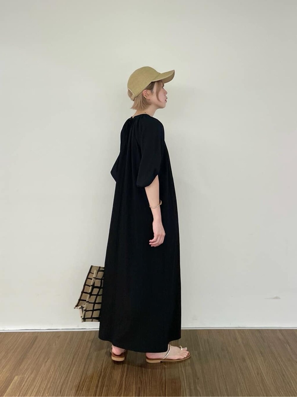ブラック系のワンピース、ベージュ系のトートバッグ、ゴールド系のリングを着用したレディースの夏コーディネートの8枚目の写真