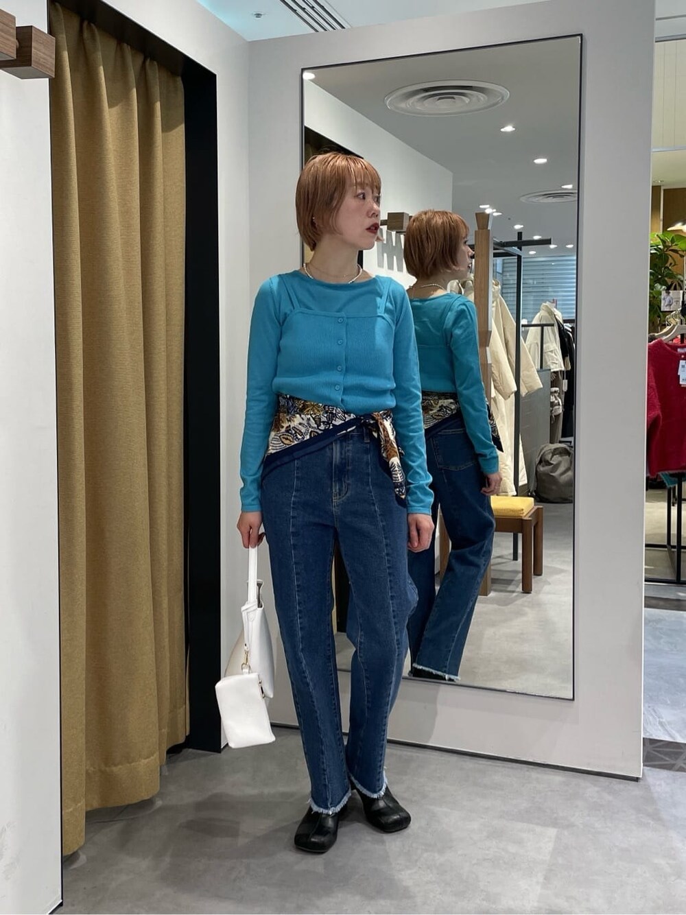 パープル系のTシャツ/カットソー、ブルー系のデニムパンツ、ブルー系のニット/セーターを着用したレディースの冬コーディネートの7枚目の写真