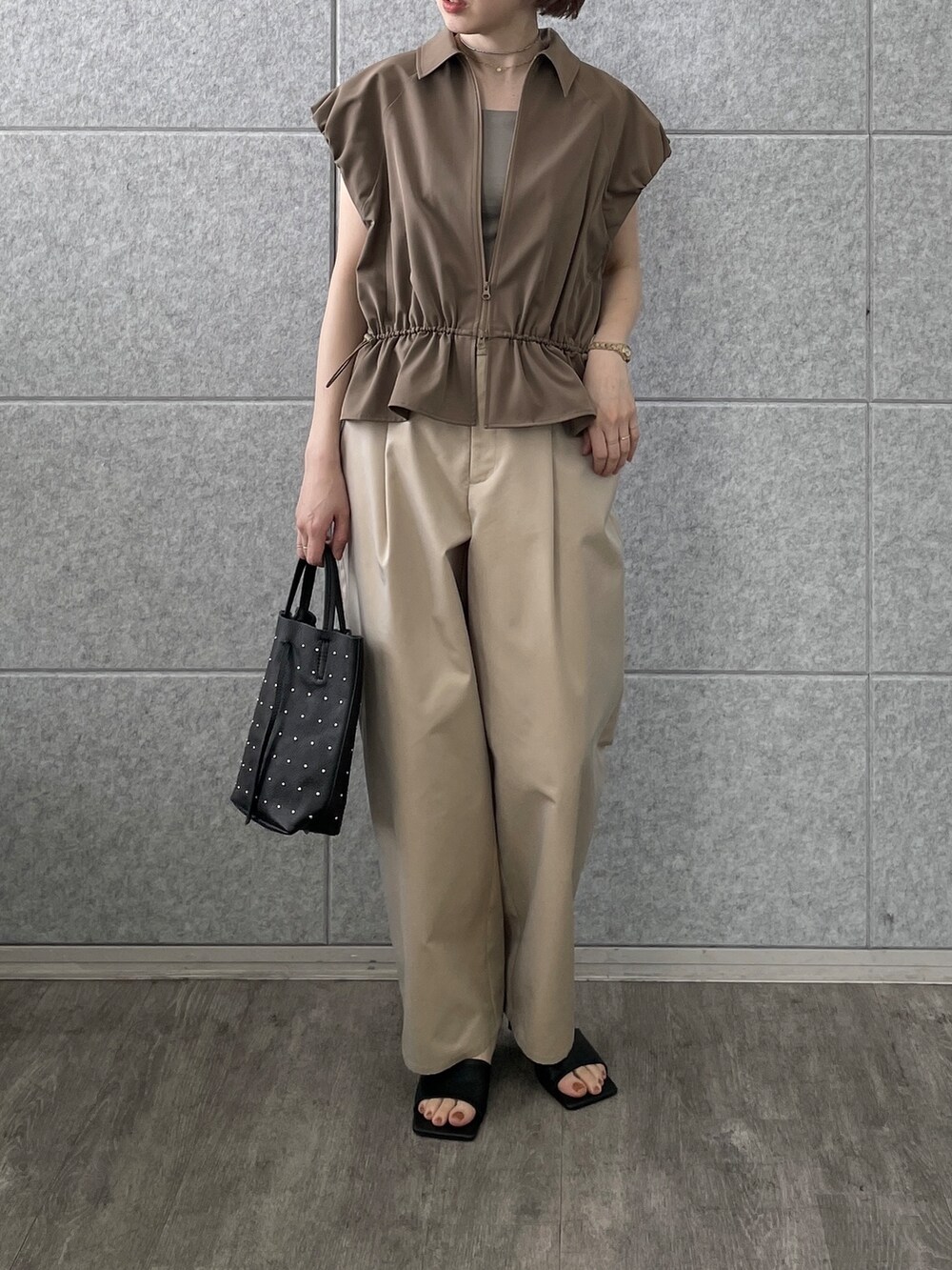 ベージュ系のその他パンツ、ブラック系のトートバッグ、ブラウン系のブルゾンを着用したレディースの春コーディネートの3枚目の写真