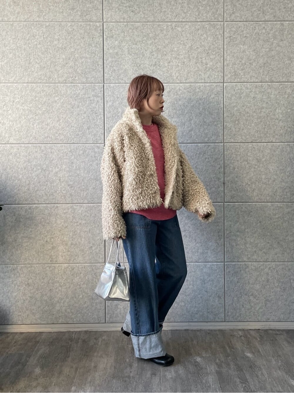 ピンク系のニット/セーター、ブルー系のデニムパンツを着用したレディースの冬コーディネートの8枚目の写真