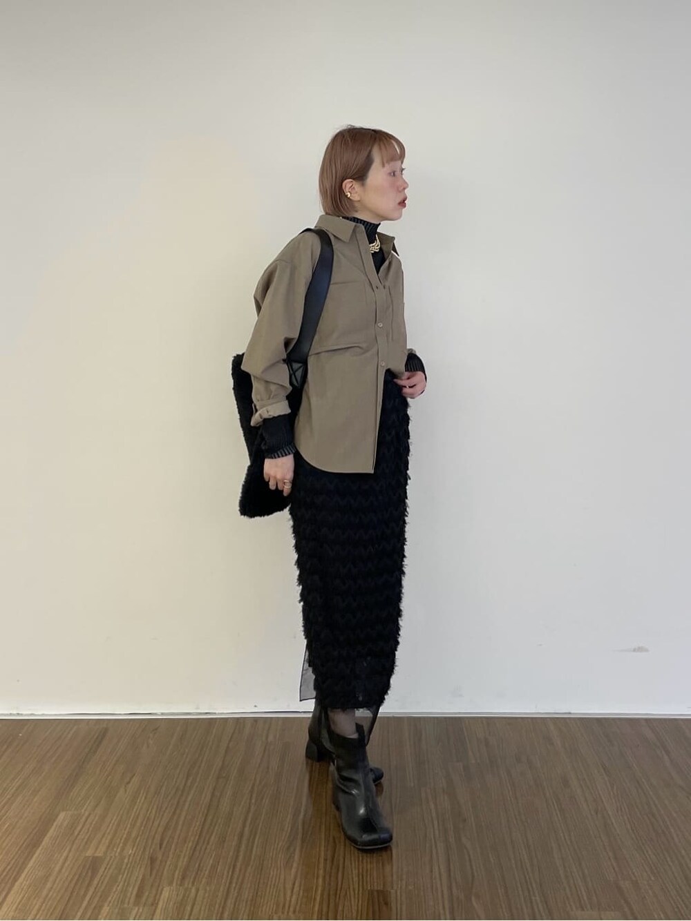 ベージュ系のシャツ/ブラウス、ブラック系のニット/セーター、ブラック系のスカートを着用したレディースの冬コーディネートの2枚目の写真