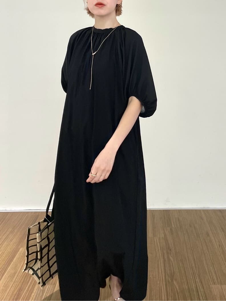 ブラック系のワンピース、ベージュ系のトートバッグ、ゴールド系のリングを着用したレディースの夏コーディネートの6枚目の写真