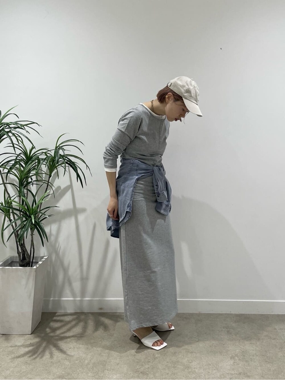 グレー系のワンピース、ホワイト系のサンダル、ブルー系のシャツ/ブラウスを着用したレディースの春コーディネートの7枚目の写真