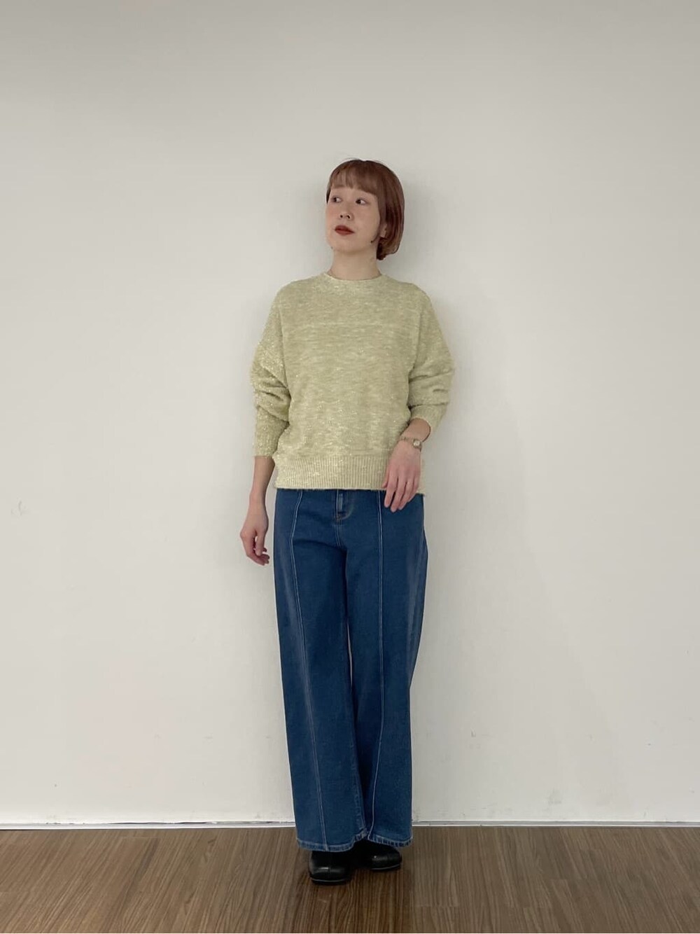 ブルー系のデニムパンツ、ゴールド系のニット/セーターを着用したレディースの秋コーディネートの5枚目の写真