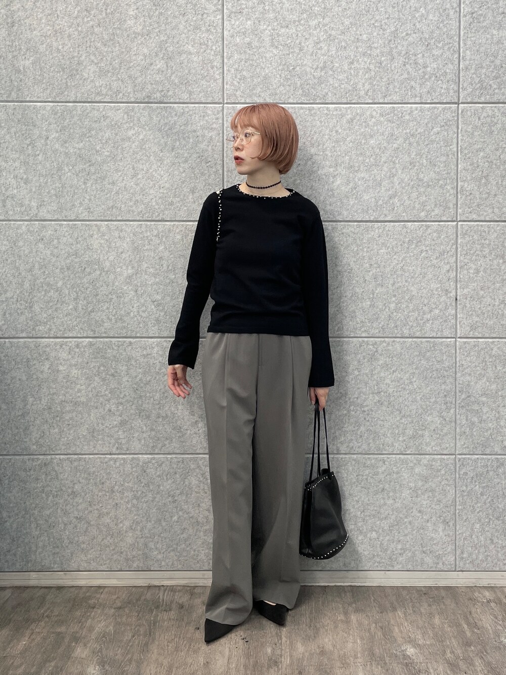 グレー系のその他パンツ、シルバー系のハンドバッグ、ブラック系のニット/セーターを着用したレディースの夏コーディネートの9枚目の写真