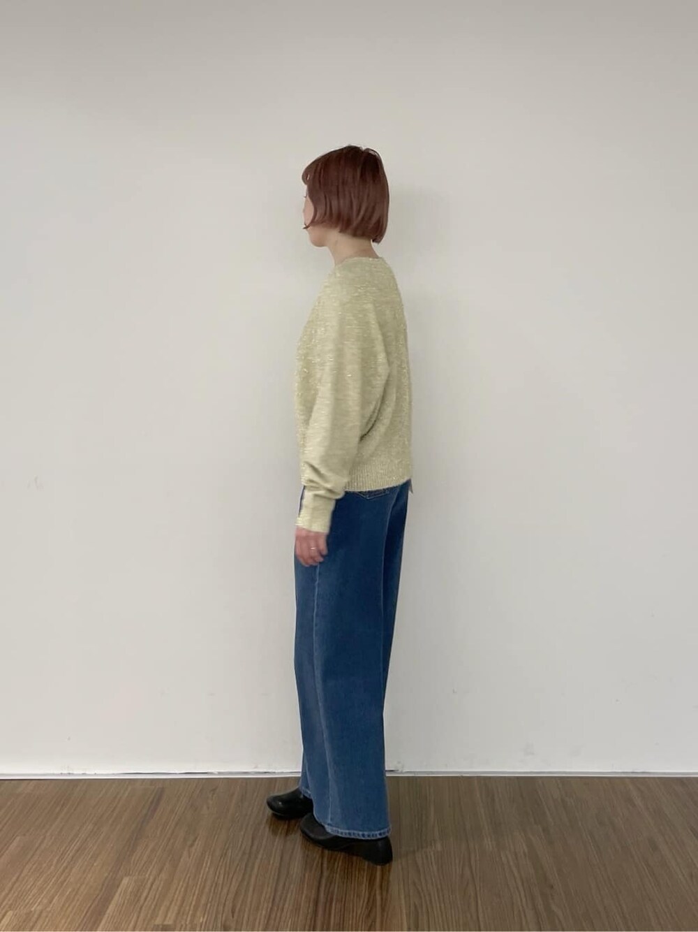 ブルー系のデニムパンツ、ゴールド系のニット/セーターを着用したレディースの秋コーディネートの3枚目の写真