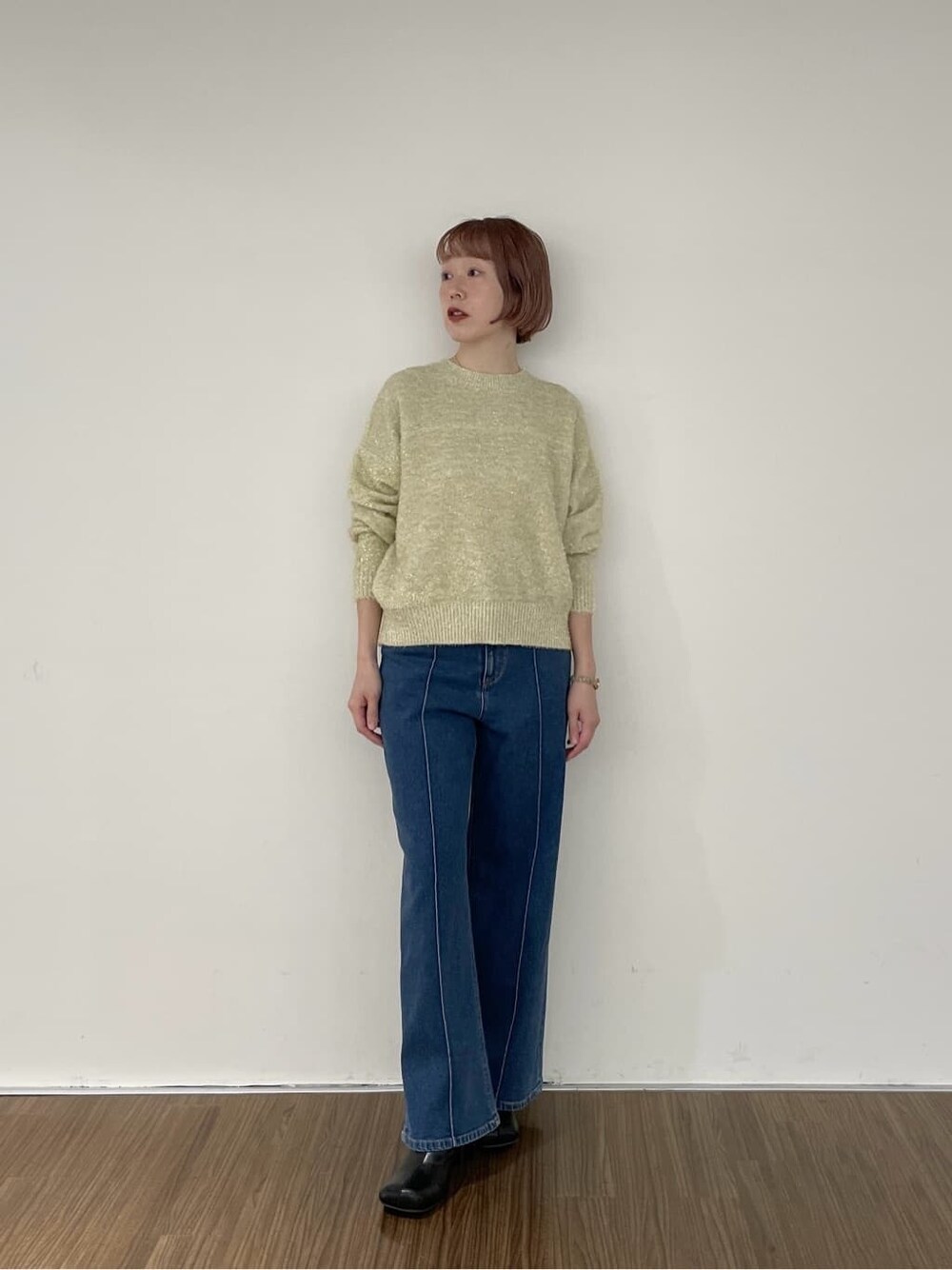 ブルー系のデニムパンツ、ゴールド系のニット/セーターを着用したレディースの秋コーディネートの6枚目の写真