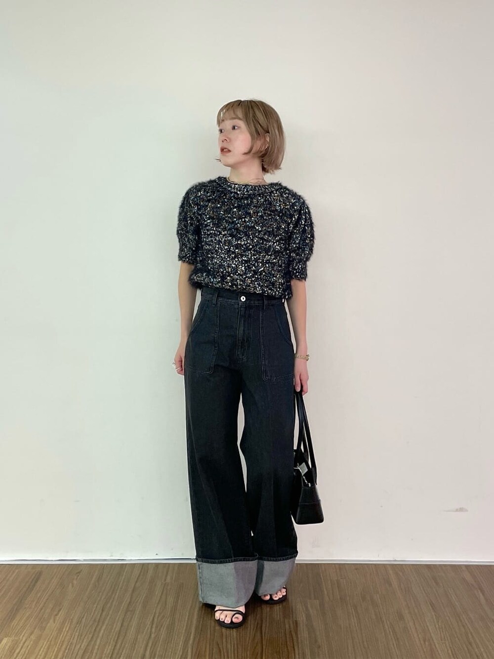 ブラック系のニット/セーター、グレー系のデニムパンツを着用したレディースの夏コーディネートの9枚目の写真