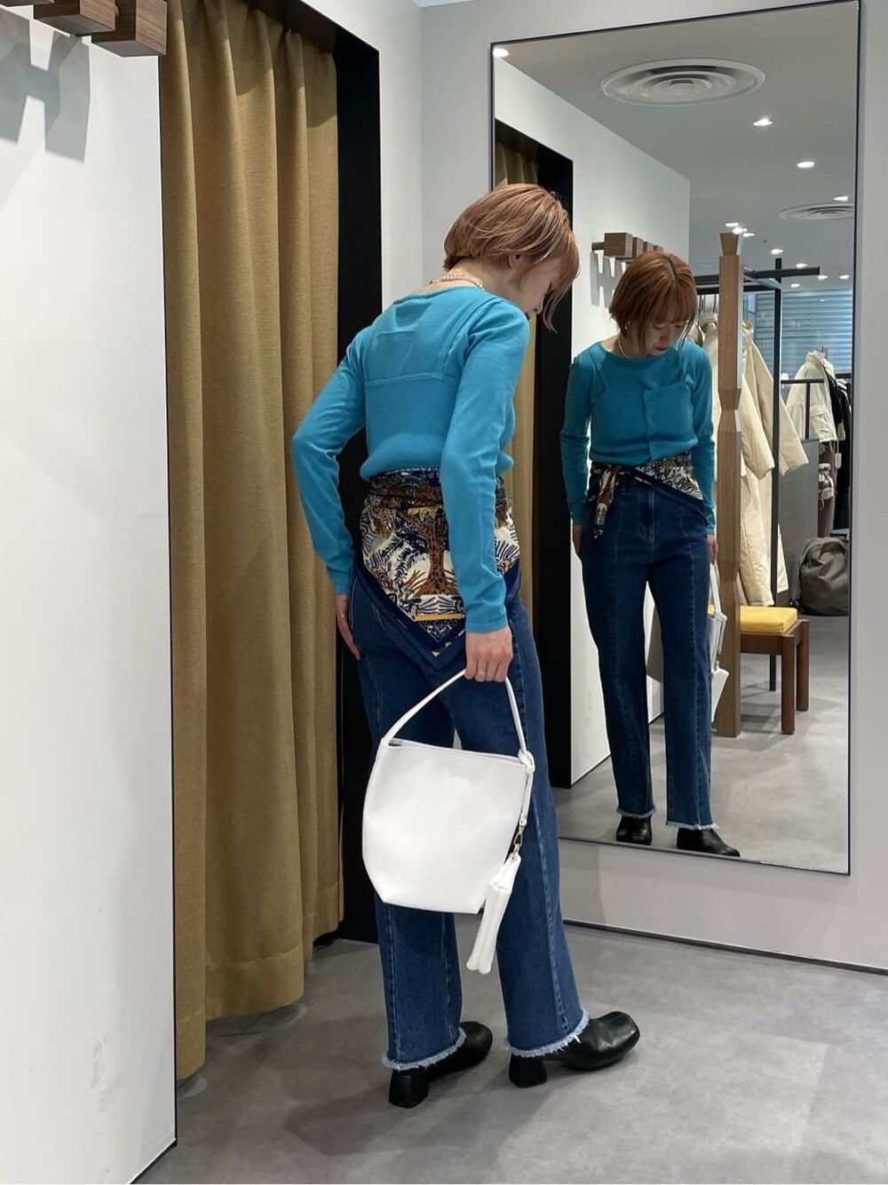 パープル系のTシャツ/カットソー、ブルー系のデニムパンツ、ブルー系のニット/セーターを着用したレディースの冬コーディネートの3枚目の写真
