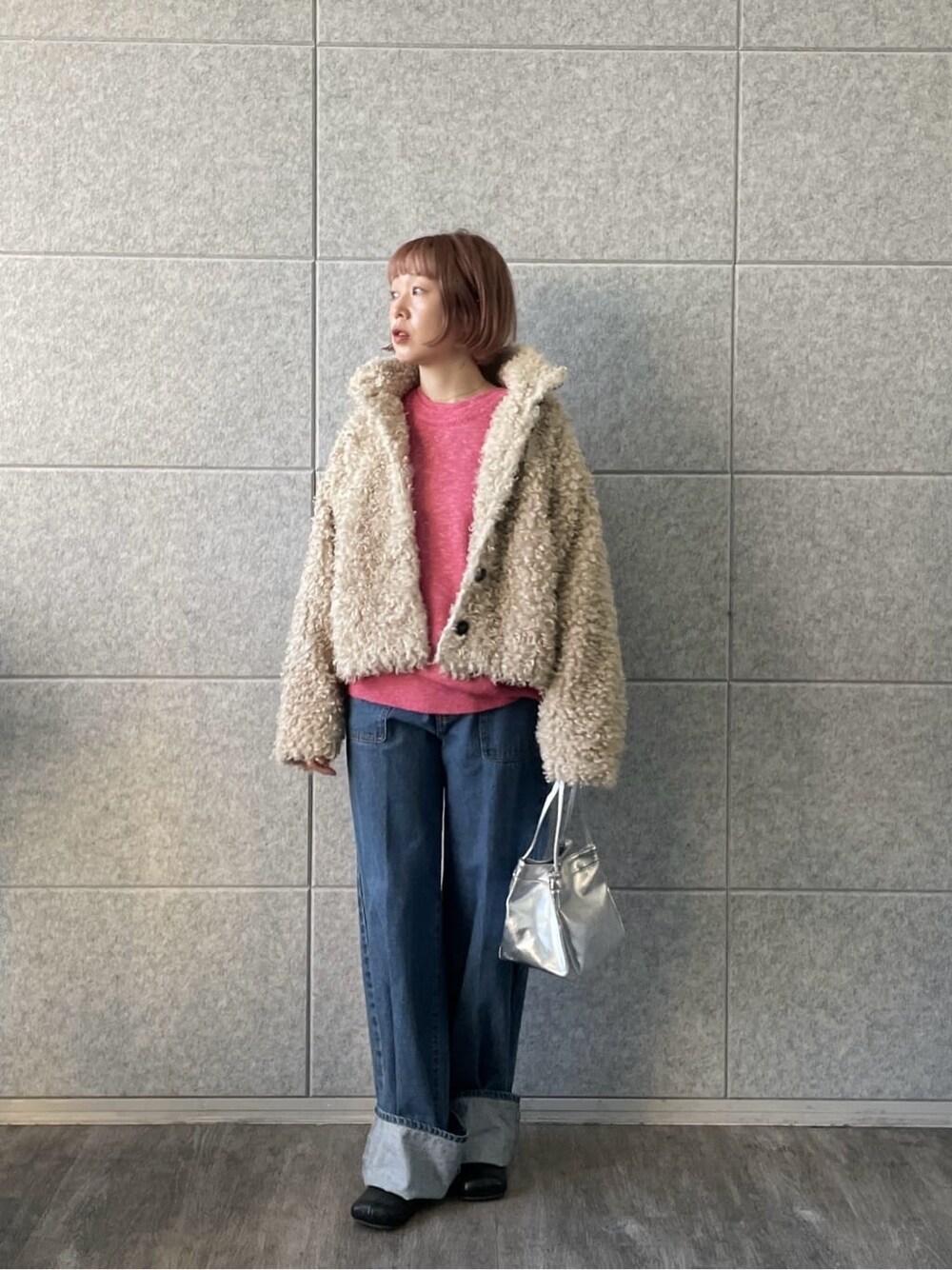ピンク系のニット/セーター、ブルー系のデニムパンツを着用したレディースの冬コーディネートの7枚目の写真