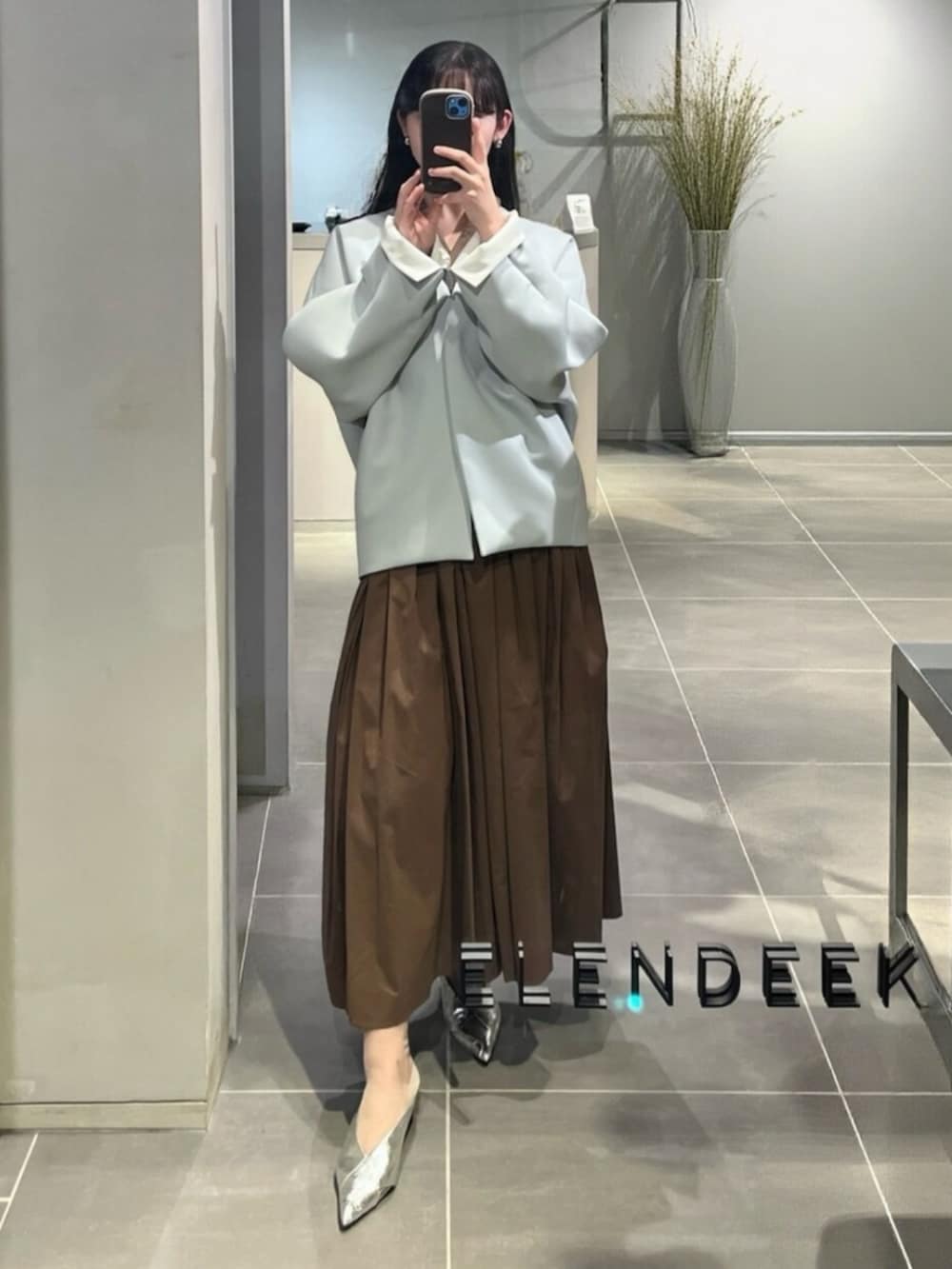 シルバー系のパンプス、ブラウン系のワンピース、グリーン系のトートバッグを着用したレディースの春コーディネートの4枚目の写真