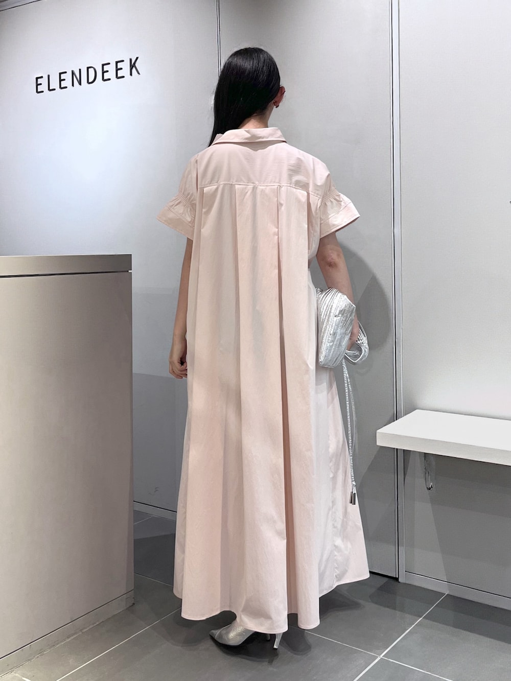 シルバー系のトートバッグ、シルバー系のパンプス、ピンク系のワンピースを着用したレディースの夏コーディネートの3枚目の写真