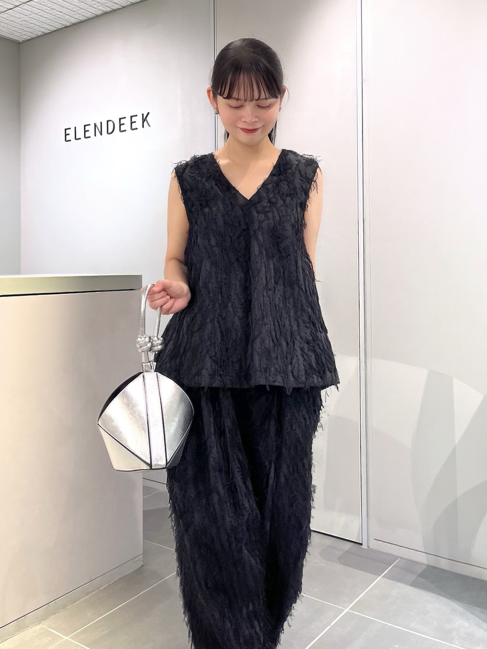 ブラック系のシャツ/ブラウス、ブラック系のその他パンツ、シルバー系のパンプスを着用したレディースの夏コーディネートの5枚目の写真