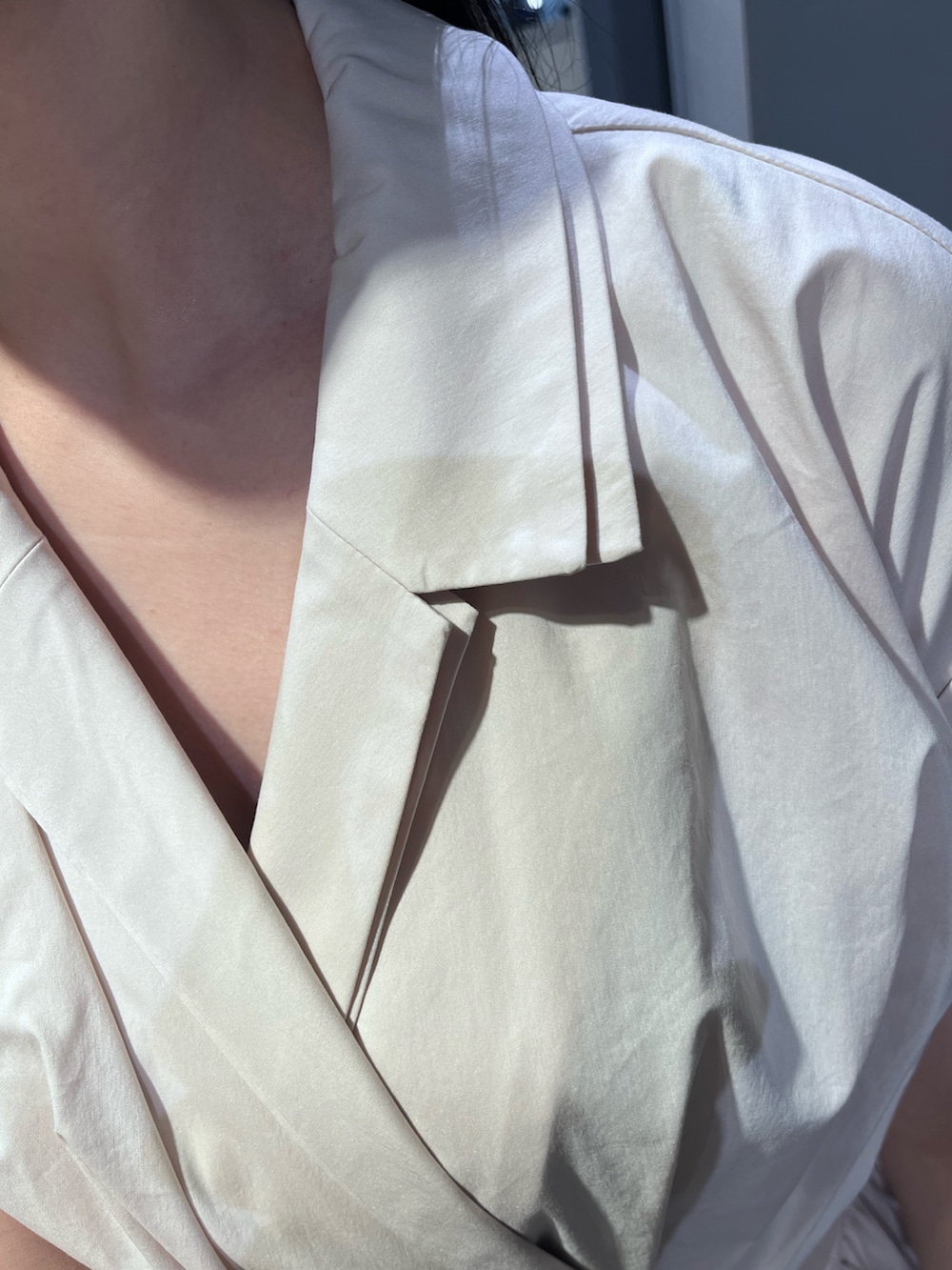 ベージュ系のワンピース、パープル系のハンドバッグ、シルバー系のパンプスを着用したレディースの春コーディネートの5枚目の写真