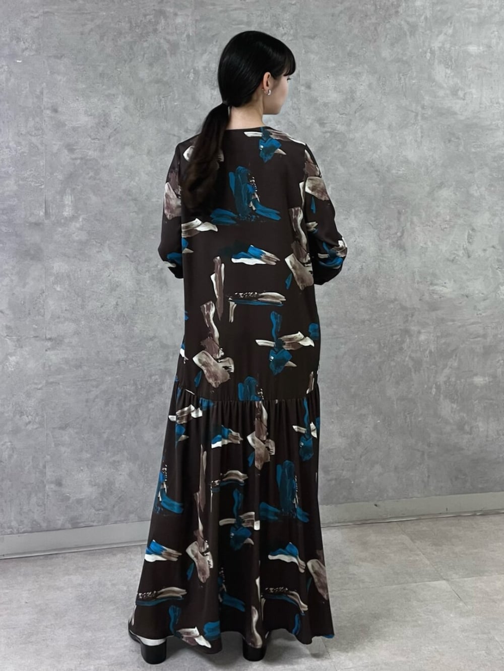 ブラウン系のワンピース、イエロー系のハンドバッグ、シルバー系のパンプスを着用したレディースの秋コーディネートの4枚目の写真