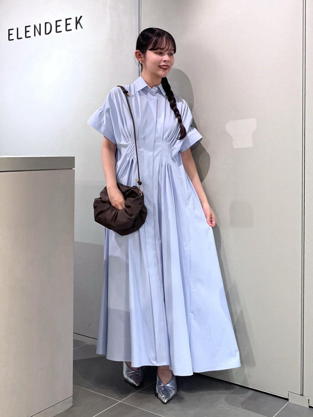 シルバー系のパンプス、ブラウン系のハンドバッグ、ブルー系のワンピースを着用したレディースの夏コーディネートの5枚目の写真
