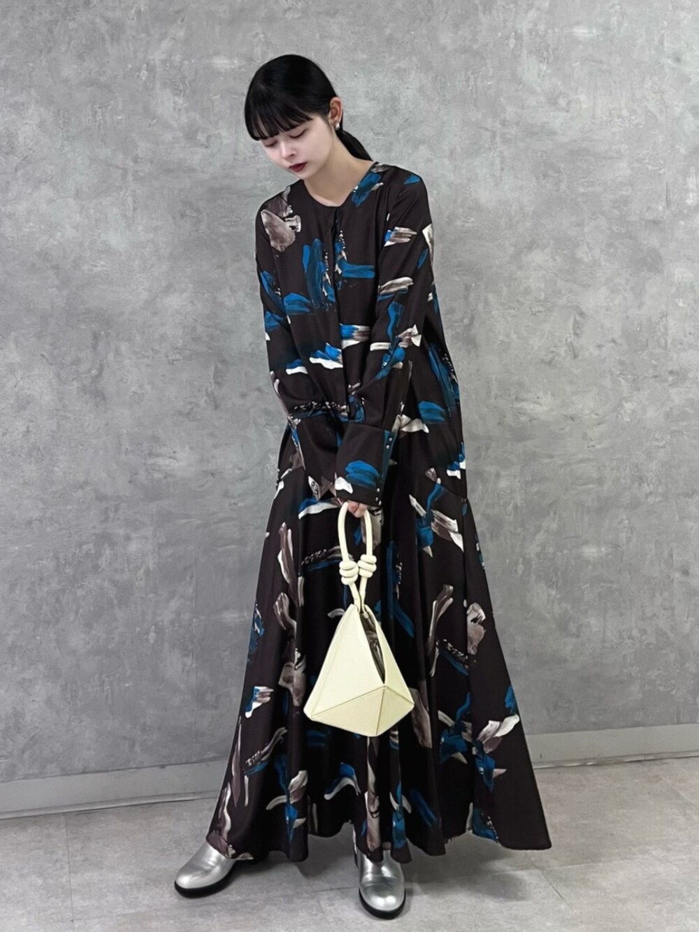 ブラウン系のワンピース、イエロー系のハンドバッグ、シルバー系のパンプスを着用したレディースの秋コーディネートの2枚目の写真