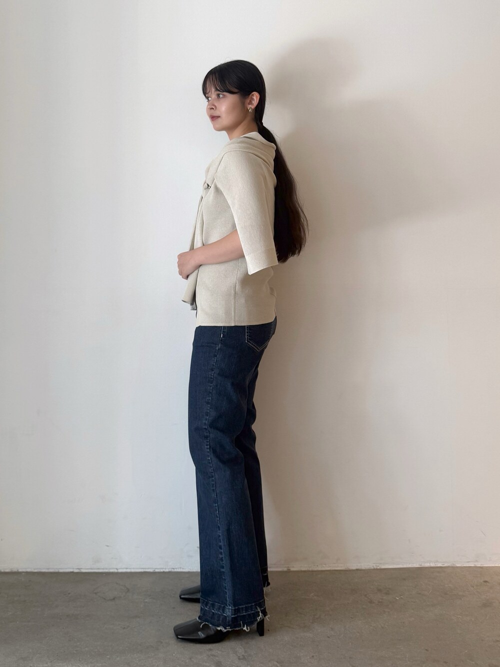 ベージュ系のカーディガン/ボレロ、ブルー系のデニムパンツ、ブラック系のブーツを着用したレディースの夏コーディネートの4枚目の写真