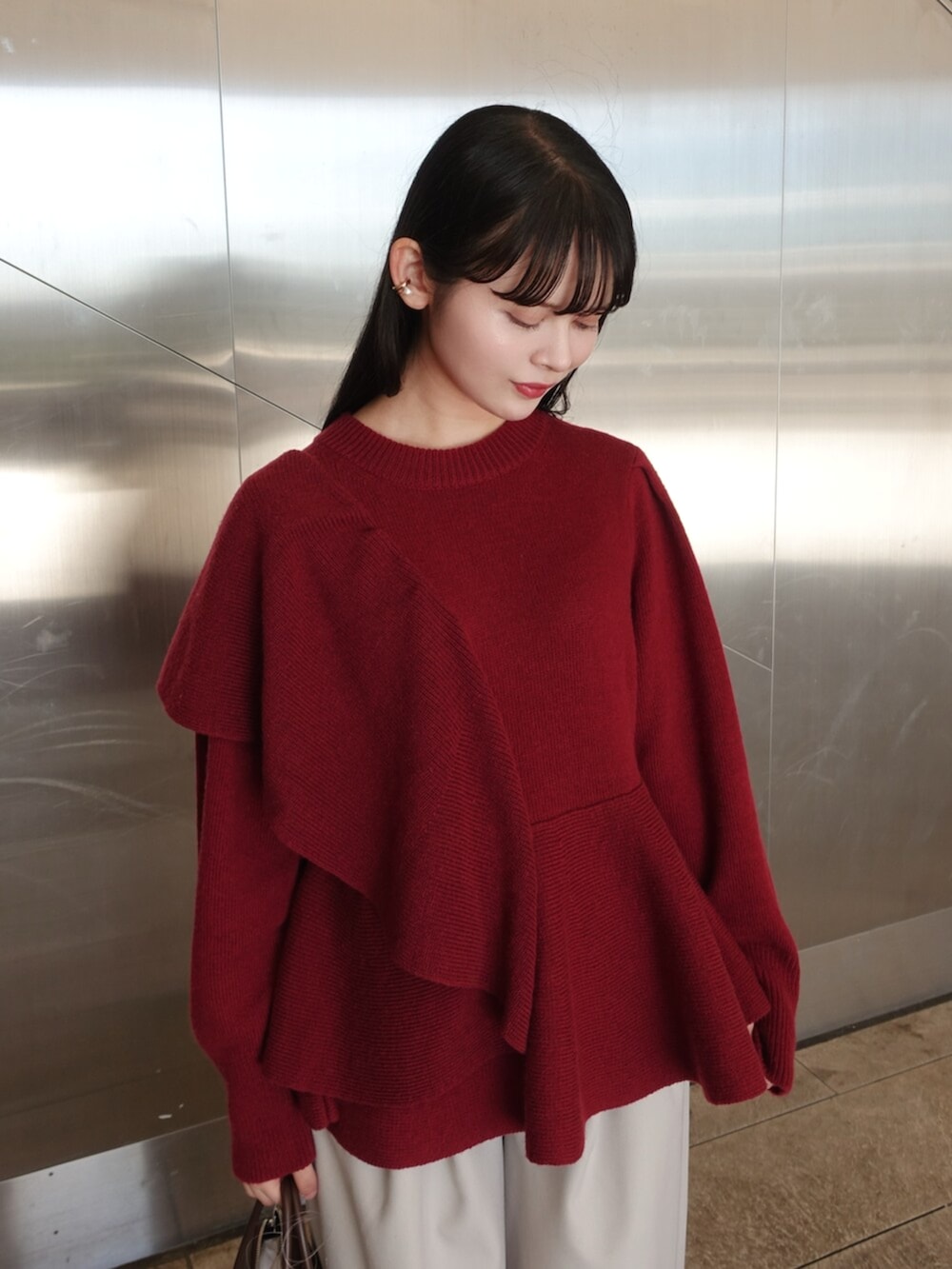 レッド系のニット/セーター、ホワイト系のその他パンツ、ブラック系のボストンバッグを着用したレディースの冬コーディネートの5枚目の写真