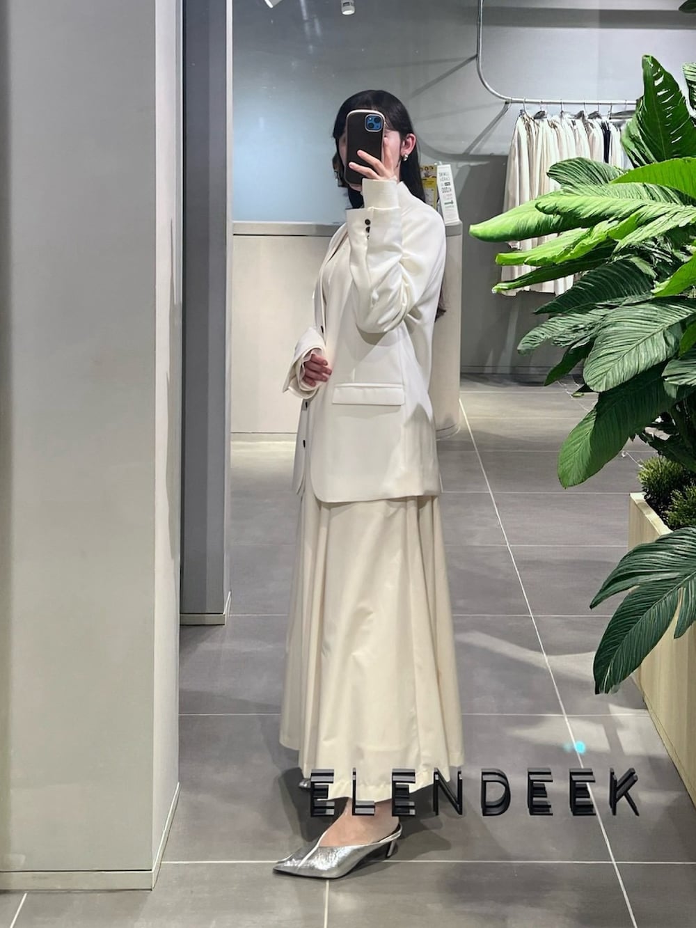 ホワイト系のノーカラージャケット、シルバー系のパンプス、ホワイト系のワンピースを着用したレディースの春コーディネートの2枚目の写真