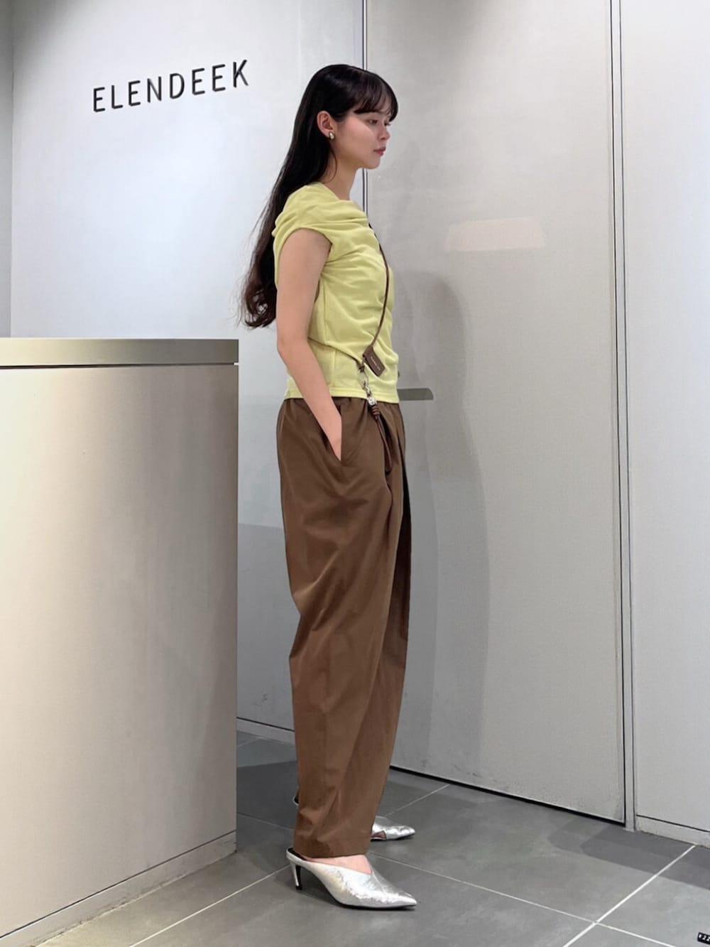 シルバー系のパンプス、グリーン系のTシャツ/カットソー、ブラウン系のその他パンツを着用したレディースの夏コーディネートの2枚目の写真