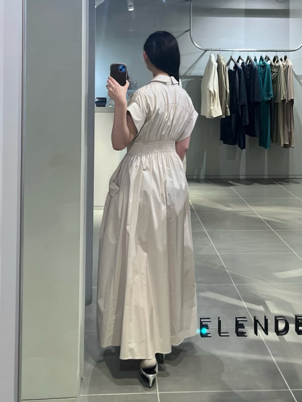 ベージュ系のワンピース、パープル系のハンドバッグ、シルバー系のパンプスを着用したレディースの春コーディネートの3枚目の写真